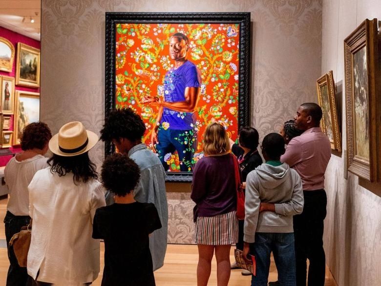 Bezoekers bekijken een kleurrijk schilderij in een galerieruimte