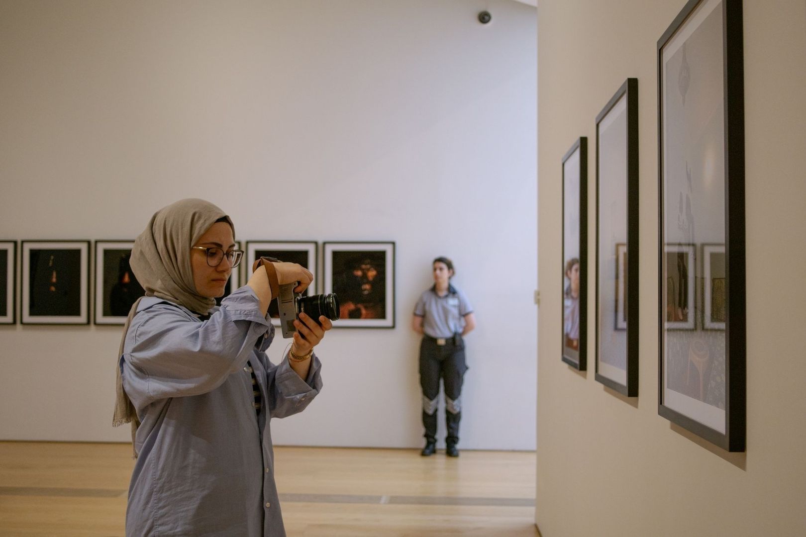Bezoeker fotografeert kunstwerken in een museumzaal
